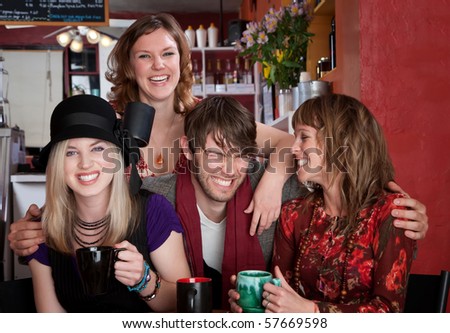 Charismatic young hipster with three female friends at a cafe