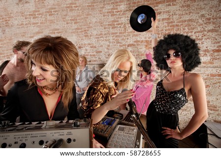 stock photo Three female DJs performing at a 1970s Disco Music Party