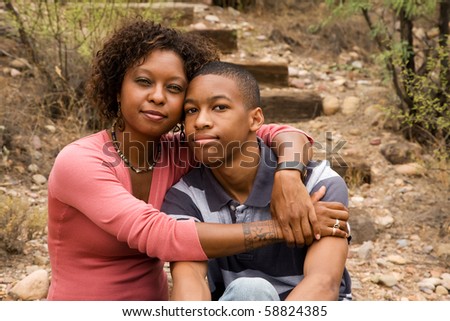 Loving single-mother hugging her handsome teenage son