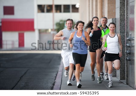 Men and women running for exercise downtown