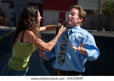 Angry woman helps fix a hapless mans shirt and tie