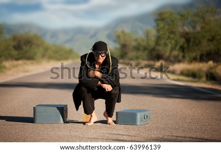 Strange indigenous man in the middle of a road with suitcases
