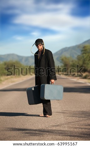 Strange indigenous man in the middle of a road with suitcases