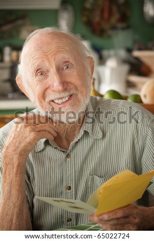 Senior man at home reading greeting card