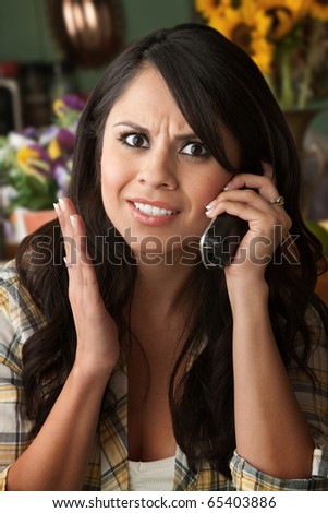 Frustrated Latina Woman on Phone  Waiting for Service or taking Sales call