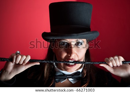 Woman dressed like a circus ringmaster with whip