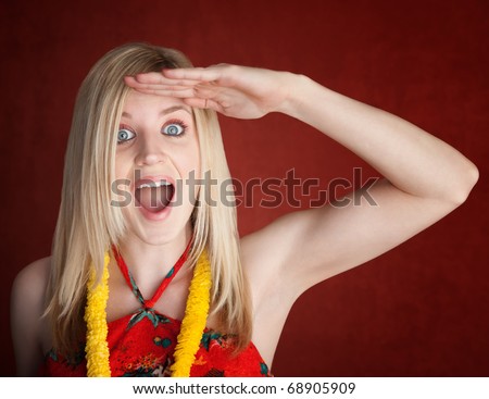 A beautiful female tourist looks on with hand on forehead