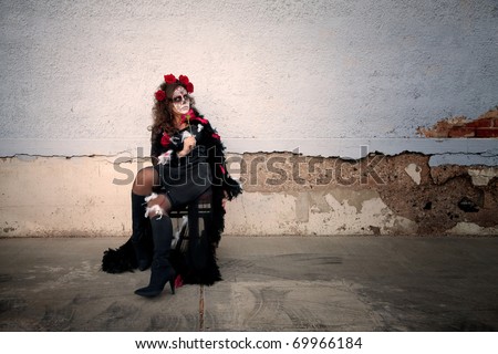 Woman with makeup for All Souls Day sits outside on a chair