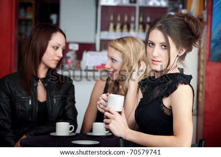 Gorgeous teenaged girl listening to music while her friends converse