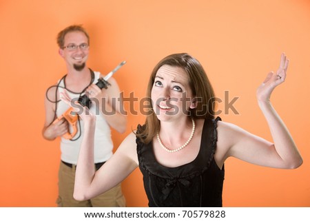 Frustrated young woman and handy husband with reciprocal saw