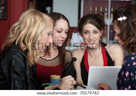 Young female college student studying with three friends in a cafe