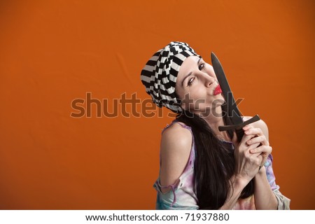 Young woman in tie-dye kisses a dagger