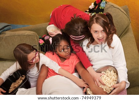 Little girls grab popcorn at a sleepover