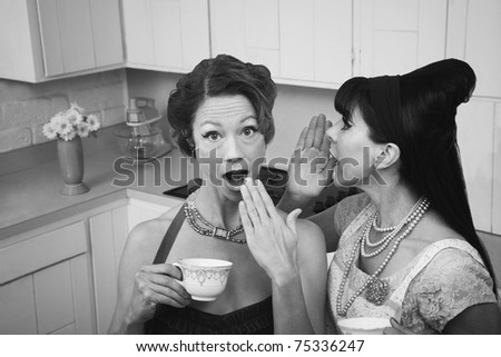 Woman whispers secret into a friend\'s ear