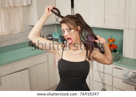 Screaming woman pulls her hair in a kitchen