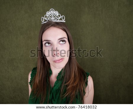 Pretty Caucasian woman with small crown daydreams