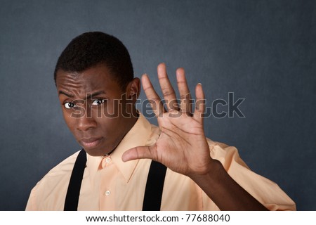Young handsome Black male gestures with palm to stay away