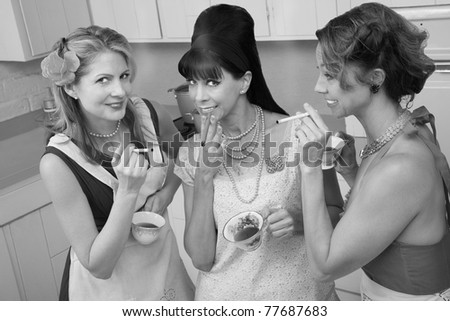 Three middle-aged woman smoke in a retro-style tea party