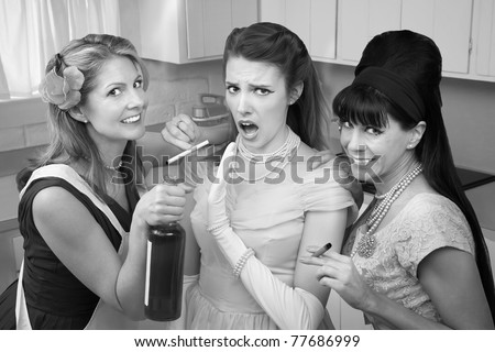 Young woman with her friends smoking and drinking in the kitchen