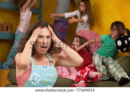 Upset mother with hands on head among mischievous little girls Upset mother with hands on head among mischievous little girls