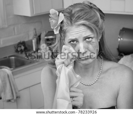 Caucasian housewife wipes tears with napkin in her kitchen