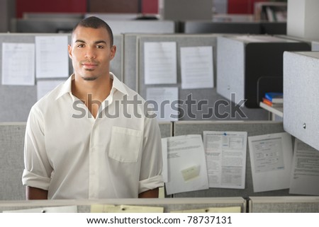 Portrait of handsome man standing in office cubicle