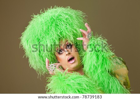 Drag queen wearing boa hat on green background