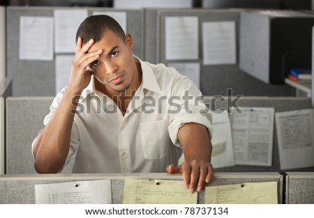 Stressed-out Latino office worker with hand on his head