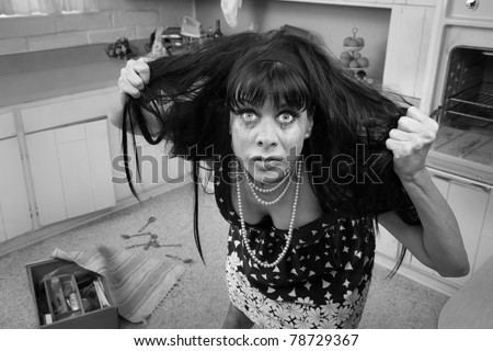 Desperate housewife in a kitchen pulls her hair