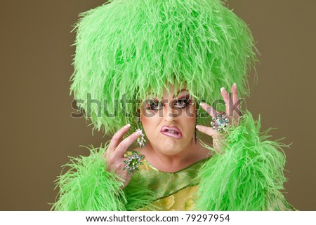 Big drag queen in green outfit twists her lips