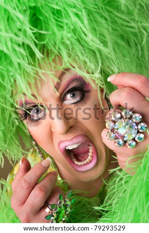 Scared drag queen wearing heavy makeup and boa hat