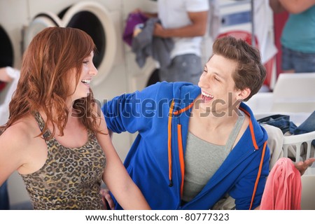 Man and woman laugh about his white shirt turned pink