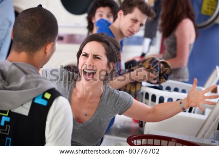 Frustrated young woman yells at a man in the laundromat