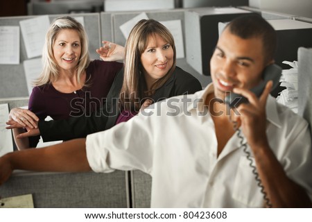 Women office workers flirt with handsome male coworker in office