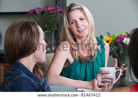 Middle-aged Caucasian woman enjoys cup of coffee with friends