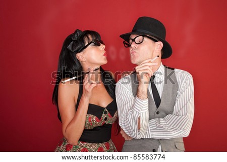 Retro-style couple blow smoke rings at each other