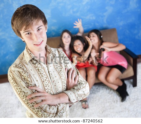 Happy young man with three adoring girls on sofa