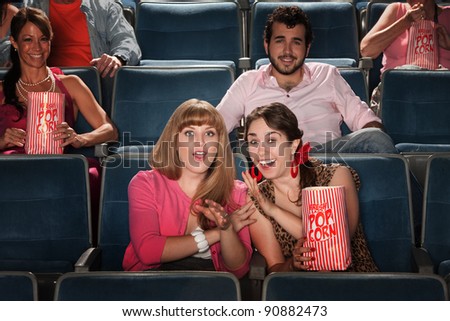 Friends with a bag of popcorn in theater