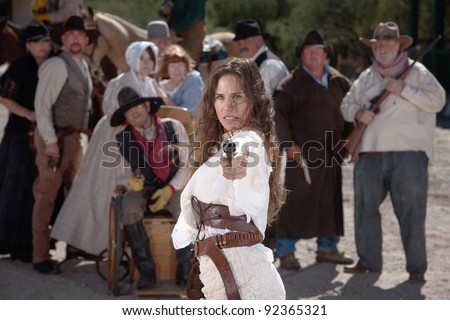Strong old west woman points her gun defiantly