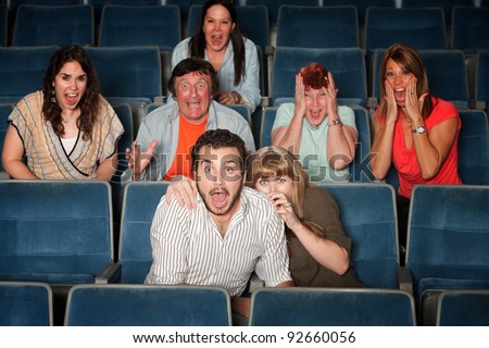 Scared group of people scream out in theater