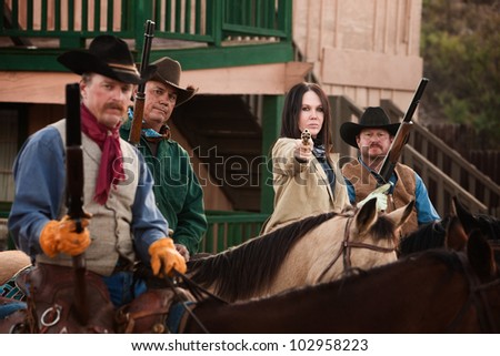 Old American west woman with pistol and 3 armed men