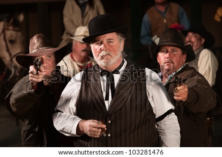Tough old west gambler with armed friends