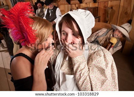 Two ladies whisper to each other as drunk cowboy listens