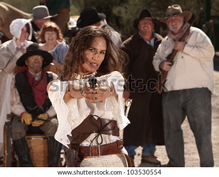 Mexican woman in old west style clothes points her gun