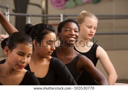 Proud ballet student with peers in a dance studio