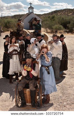 People in American old west scene with weapons in front of church