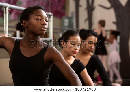 Three young ballet dancers in a dance studio