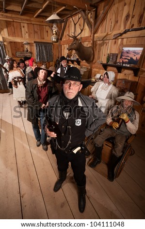 Tough sheriff with sad customers in old American west saloon
