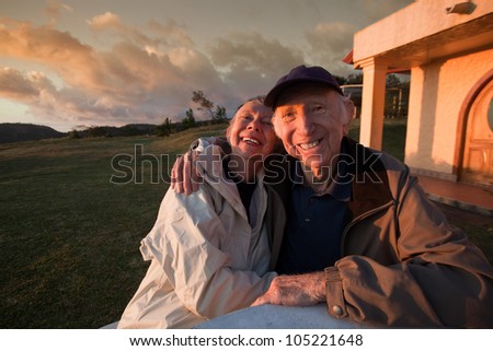 Loving elderly couple smiling at table in mountains
