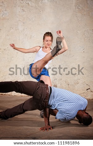 Cute female martial artist performs a Capoeria crescent kick
